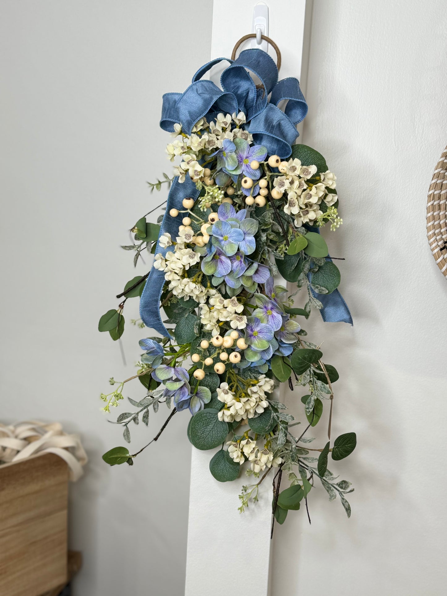 Decorated eucalyptus, wax flower, and blue hydrangea swag