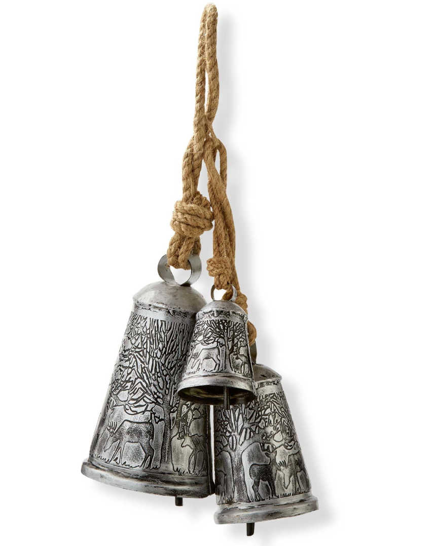 Three metal bells with intricate forest designs hanging from jute rope