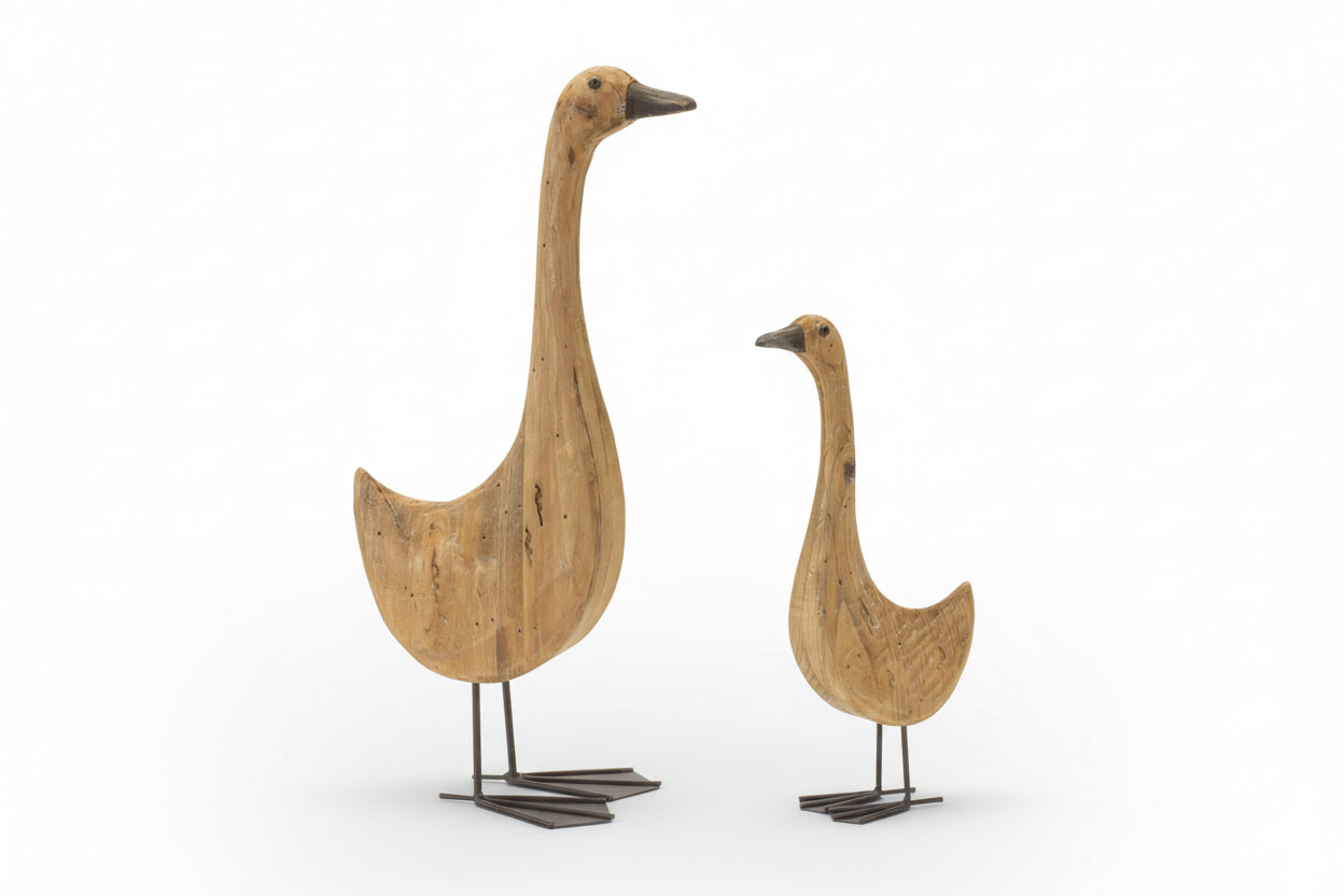 Two wooden goose sculptures on a white background