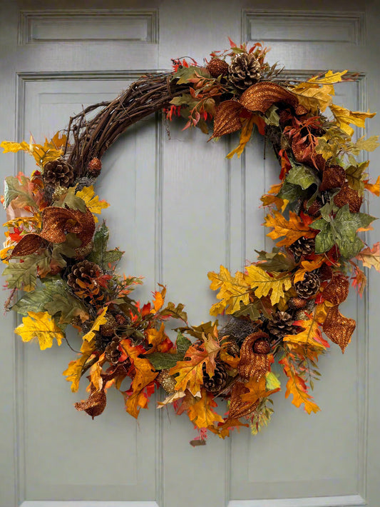 Autumn wreath with leaves and pinecones on a door