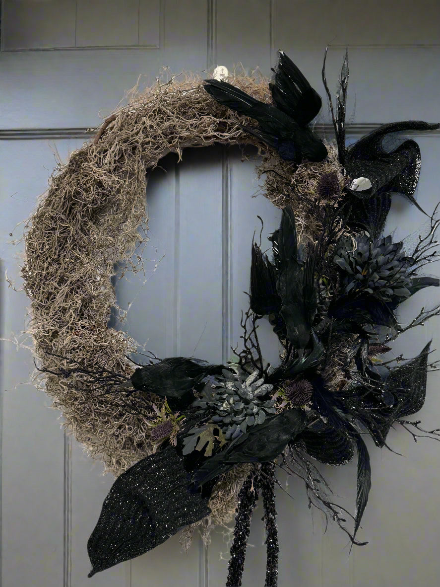Decorative wreath with black feathers and branches on a white background