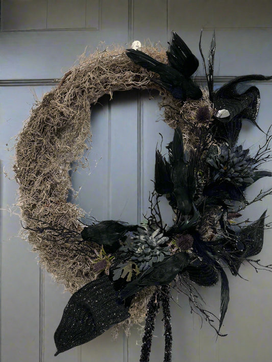 Decorative wreath with black feathers and branches on a white background