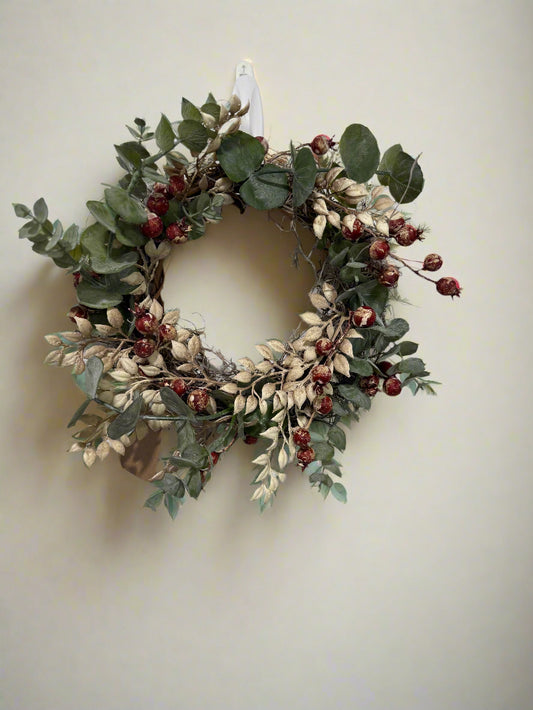 Decorative wreath with green leaves and red berries