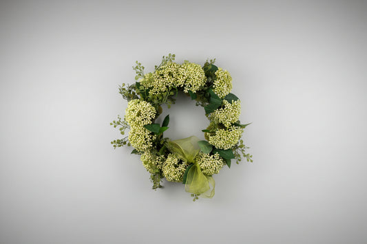 Small wreath with green tone florals and a small bow