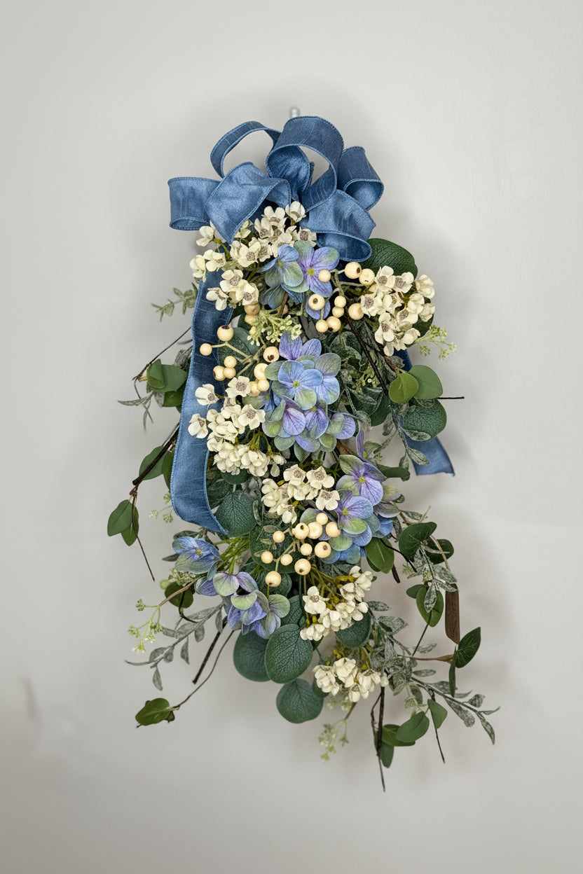 Decorated eucalyptus, wax flower, and blue hydrangea swag